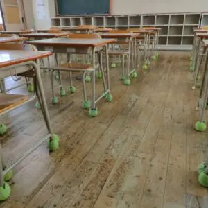 テニスボール リサイクル活動の一環として学校の椅子や脚に装着され消音・防音効果を発揮する様子