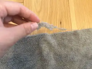 古タオル再利用のウエスを割いた際に出たわずかな糸くずをハサミで切り整える工程